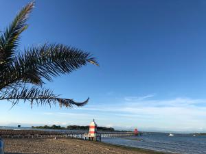 czerwono-biała latarnia morska na plaży przy wodzie w obiekcie Marine House w Lignano Sabbiadoro