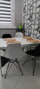 - une table et des chaises blanches dans la chambre dans l'établissement Apartament 25, à Płock