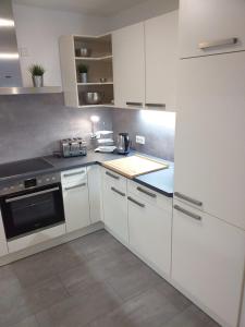 a kitchen with white cabinets and a counter top at Ferienwohnung Am Michelsbach in Boppard