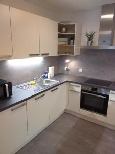 a kitchen with white cabinets and a sink at Ferienwohnung Am Michelsbach in Boppard