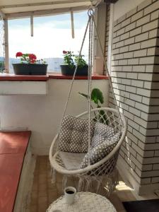 a hanging chair on a balcony with a window at Vila Zora apartman in Banja Koviljača