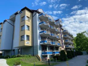 un edificio de apartamentos con balcones azules en Apartment Sand Castle with free parking, en Świnoujście