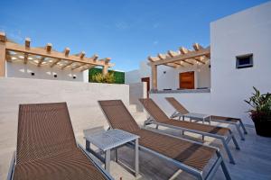 a group of chairs and a table on a patio at MAYAN MONK Suites in Playa del Carmen