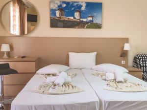 a bedroom with a white bed with a mirror at Jimmy's rooms nea potidea in Nea Potidaea