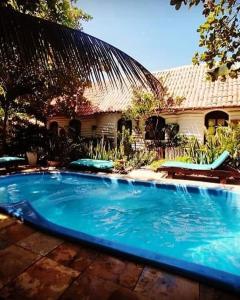 una gran piscina azul frente a una casa en Pousada JeriMagia en Jericoacoara