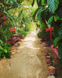 un camino de tierra con una cruz roja y una silla roja en Pousada JeriMagia en Jericoacoara