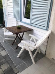 a bench and a table and chairs on a porch at Klara Apartmanház in Orfű