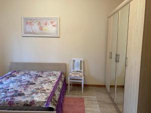 a bedroom with a bed and a chair at Дом у моря in Odesa