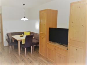 ein Wohnzimmer mit einem Tisch und einem TV in der Unterkunft Haus Angelika in Ehrwald