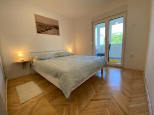 a bedroom with a large bed and a large window at Blue View Apartment in Crikvenica