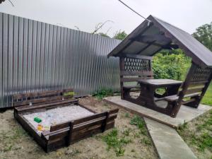 un cenador y una mesa de picnic en un jardín en Private House, en Beregovo