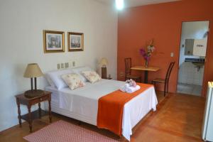 Un dormitorio con una cama y una mesa con flores. en Espaço Mascattes Pousada, en Serra do Cipo