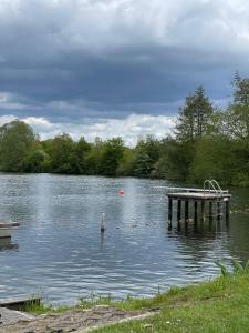 a lake with a dock in the middle of it at vakantiehuis Cerise, Luxueus genieten in de Leiestreek in Deinze