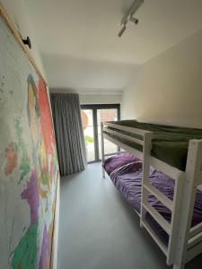 una camera con letto a castello e una mappa sul muro di vakantiehuis Cerise, Luxueus genieten in de Leiestreek a Deinze