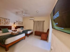 a hotel room with two beds and a football scoreboard at Villas Bliss 18 in Isla Mujeres
