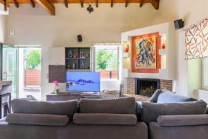 a living room with a couch and a tv at Sunshine House Corfu in Anemómylos