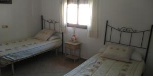 - une chambre avec 2 lits et une fenêtre dans l'établissement Alojamiento rural " Las Carmenes ", à Algar 10 autres photos