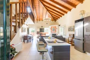 an open kitchen and living room with wooden ceilings at Sunshine House Corfu in Anemómylos