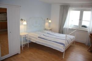 ein Schlafzimmer mit einem Bett, zwei Tischen und einem Fenster in der Unterkunft Haus Norden in Grömitz