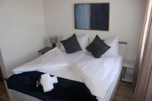 a white bed with pillows on it in a room at Hotel Rosengärtli in Leissigen +25 photos