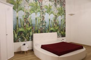 - une chambre avec un lit et une fresque murale de palmiers dans l'établissement Villa Alisia, à Zingarello