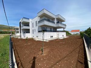 een wit huis met een tuin ervoor bij Villa Tragurium in Trogir