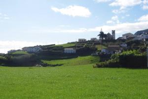 a green field with houses on top of a hill at Casa J Dias in Nordeste