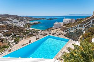 an infinity pool with a view of the ocean at Villa Thelgo Mykonos in Psarou