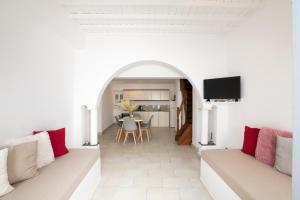 a living room with white walls and red pillows at Alessios Houses Mykonos Town in Mýkonos City