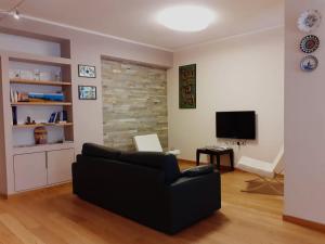 a living room with a black couch and a television at Belo Horizonte in Civitanova Marche