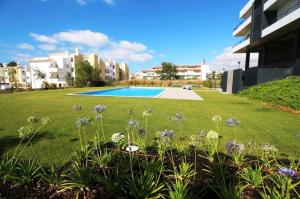 einen Garten mit Pool und Blumen in der Unterkunft Casa Sensa in Albufeira