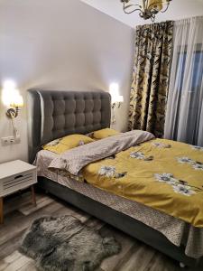 - une chambre avec un grand lit et un couvre-lit jaune dans l'établissement Apartmant Melinda M26, à Braşov