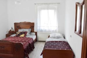 庫多瓦－茲德魯伊的住宿－W Ziołowym Ogrodzie - pokoje z dostępną kuchnią, apartament，一间卧室设有两张床和窗户。