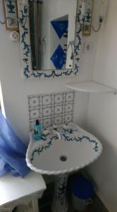 a bathroom with a blue and white sink and a mirror at Alte Schule Kirmutscheid in Müsch