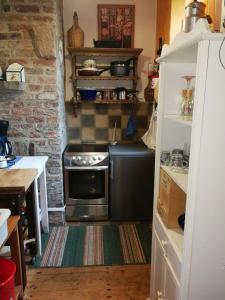 a small kitchen with a stove in a room at Alte Schule Kirmutscheid in Müsch