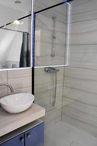Un baño con lavabo y ducha de cristal. en W Ziołowym Ogrodzie - pokoje z dostępną kuchnią, apartament, en Kudowa-Zdrój