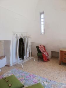 卡羅維尼奧的住宿－Trullo delle More，一间卧室,卧室内配有一张床和一把椅子