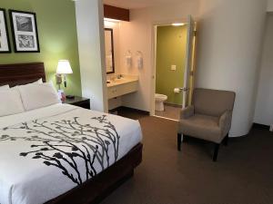 a bedroom with a bed and a chair and a bathroom at Sleep Inn Raleigh Durham Airport in Durham +57 photos