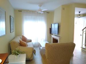 een woonkamer met een bank en een tv bij La casa del 7 in Islantilla
