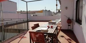 y balcón con mesa y sillas de madera. en Apartamento Turístico La Ribera, en Riolobos