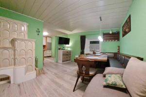 een woonkamer met groene muren en een tafel en een bank bij Murzeit Apartman in Murau