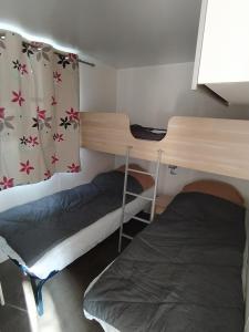 a room with two bunk beds and a window at Camping Les Peupliers in Saint-Père-en-Retz