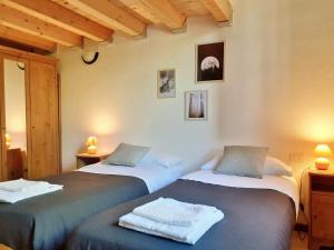 una camera da letto con due letti con asciugamani sopra di Borgo Castelluccio Country House a Porretta Terme