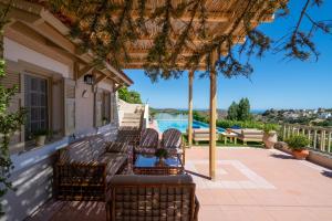 une terrasse couverte avec bancs et vue sur l'eau dans l'établissement Villa Kalo Chorio, à Kalón Khoríon