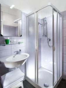 uma casa de banho branca com um chuveiro e um lavatório. em Hotel Holiday em Misano Adriatico