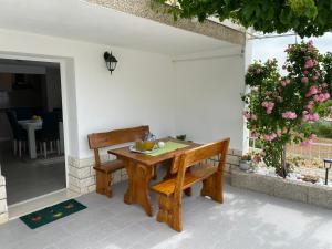 a wooden table and bench on a patio at Apartment Carmen in Trogir