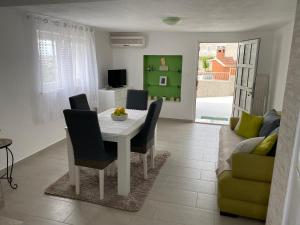 uma sala de jantar com uma mesa e cadeiras e um sofá em Apartment Carmen em Trogir