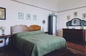 una camera da letto con un grande letto con una coperta verde di Castello Malaspina di Fosdinovo a Fosdinovo