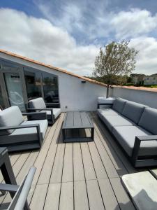 a deck with couches and a table on a building at Le Rooftop Tropézien in Saint-Tropez