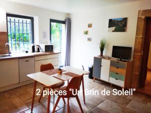 a kitchen with a table and a dining room at Appartement RDC Le Brin de soleil, Gite l Echapée Belle in Aubenas